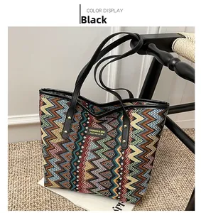 Detail of colorful woven tote bag with wave patterns and black PU leather handle
