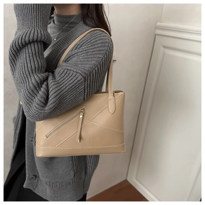Detail of light khaki lychee pattern leather tote bag with stylish stitching and side zipper