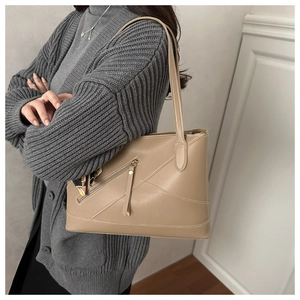 Detail of beige tote bag with decorative stitching, side zipper pocket, and printed silk scarf