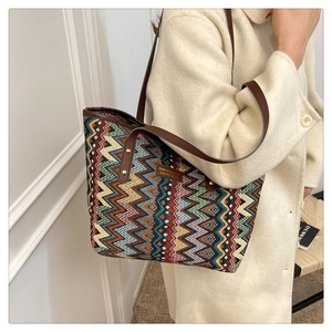 Close-up of bohemian striped tote bag with colorful wave patterns and brown leather handles