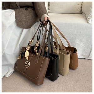 Detail view of four large tote bags in coffee, black, and beige with decorative scarves