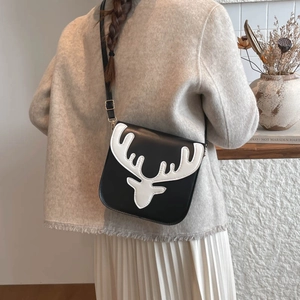 Crossbody bag with white reindeer pattern and golden metal buckles on black leather