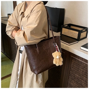 Detail of dark brown tote bag featuring retro wrinkled texture and fashion embossing