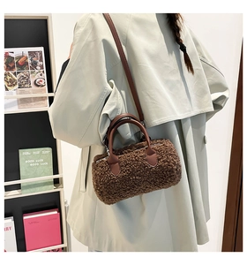 Detailed close-up of brown faux shearling cylinder bag with leather straps and texture