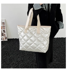 Gros plan du sac cabas matelassé blanc nacré avec poignées en sangle renforcées