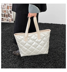 Détail du sac cabas matelassé blanc avec anses renforcées présenté dans un cadre urbain