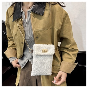 Detail of white plush crossbody bag with gold chain strap worn by a female model