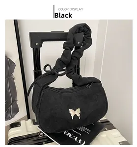 Détail du sac croissant noir avec papillon argenté et bandoulière à volants plissés