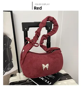 Détail du sac demi-lune bordeaux en daim avec boucle nœud argentée et bandoulière