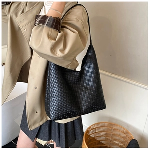 Detail of black woven hobo shoulder bag showing intricate texture and crescent shape