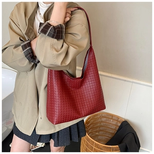 Detailed close-up of a large red woven tote bag in high-quality faux leather texture