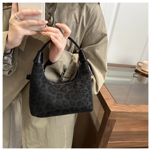 Détail du sac hobo en daim à imprimé léopard avec poignée en cuir noir et style rétro