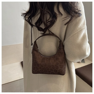 Détail du sac à main en daim à motif léopard montrant la texture et la fermeture