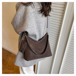 Detail of vintage brown leather hobo bag with mini envelope charm and gold hardware