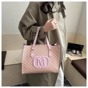 Detail of printed tote bag with M-pattern texture and pink embossed logo on stairs