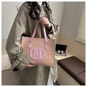 Detail of pink tote bag with M letter monogram print and embossed logo on faux leather
