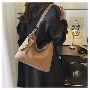 Detail of brown faux suede tote bag with small envelope pouch shown on a model's shoulder