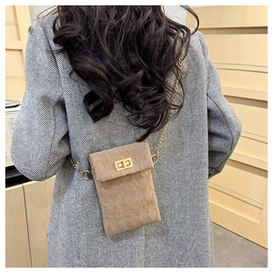 Detail of tan quilted mini bag with gold chain strap and metallic twist lock