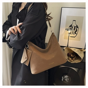 Detail of khaki suede hobo bag with small envelope pouch and gold logo lettering