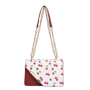Red and white crossbody flap bag with cherry pattern and golden chain strap