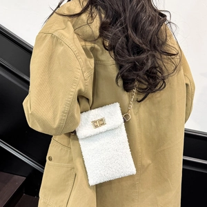 Chic white fuzzy fleece crossbody bag with gold chain strap and metal clasp worn by model