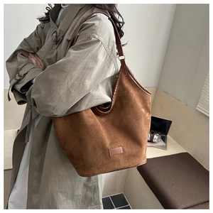 Detail of a large brown suede tote bag styled with a minimalist vintage aesthetic