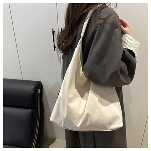 Détail du grand sac hobo minimaliste blanc cassé en cuir souple avec drapé naturel