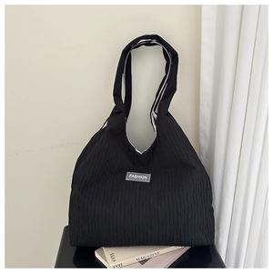 Detail of black pleated fabric texture and Fashion patch on a large tote bag