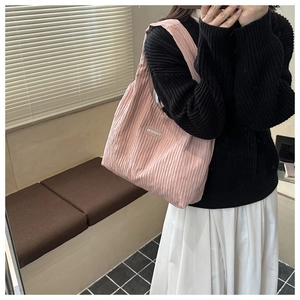 Detailed view of pink pleated tote bag with fashion label on flexible fabric