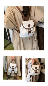 Dettaglio di uno zaino beige con coulisse, finiture marroni ed elegante fibbia in metallo