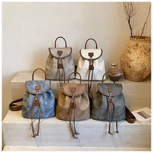 Détail de sacs à dos vintage multicolores avec texture mate élégante sur marches en pierre