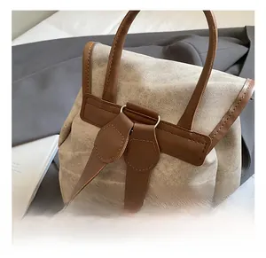 Detail showing silver ring hardware connecting beige canvas and brown leather straps