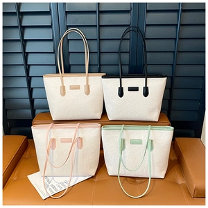 Detail view of white leather tote bags with embossed patterns in four color variations