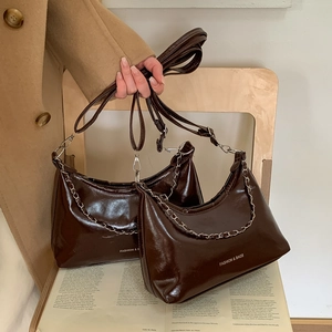 Deep brown glossy crescent shoulder bag with silver chain and Fashion & Bags text