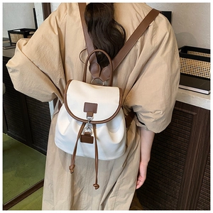 Détail d'un sac à dos en toile crème avec bretelles en similicuir marron et cordon