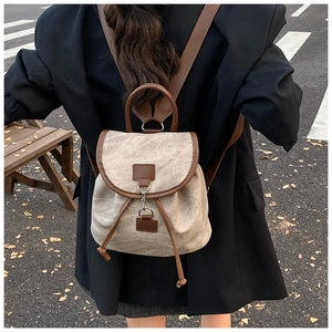 Outdoor shot showing back view of khaki canvas and brown leather mini drawstring backpack