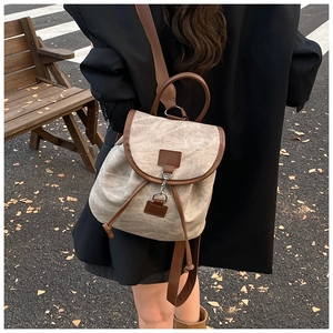 Vue détaillée du sac à dos vintage en toile avec finitions en cuir marron dans la rue