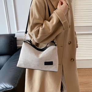 Borsa a tracolla minimalista in tela beige con finiture in pelle nera per uso quotidiano