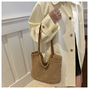 Close-up of woven tote bag with leather straps and hollow texture for beach style
