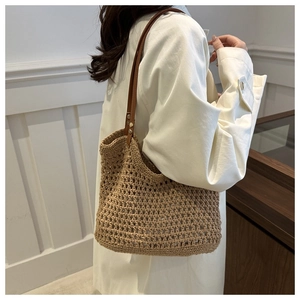 Detail of hand-crocheted khaki tote with brown leather straps for summer beach travel