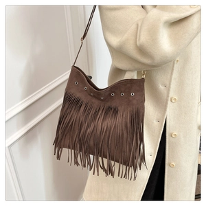 Détails du sac à bandoulière en daim marron avec franges et œillets métalliques