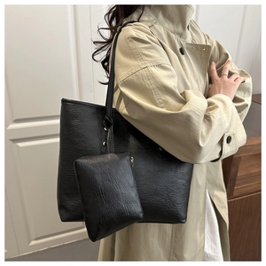 Close-up of a black lychee texture faux leather tote bag set with golden hardware details