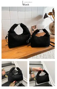 Detail of black faux shearling texture and metal handle hardware on plush crossbody bag