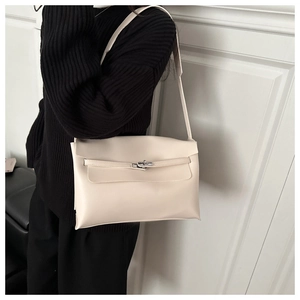 Détail du sac sous le bras en cuir crème avec fermoir rotatif en métal et lanière chic