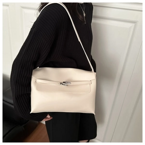 Détail du sac bandoulière en cuir crème montrant le fermoir argenté et la lanière