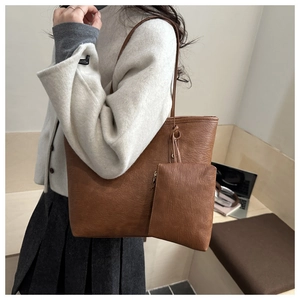 Detail of dark brown faux leather tote bag with small square zipper pouch attachment