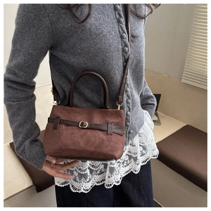 Détail du sac seau vintage marron foncé avec boucle en métal doré et bandoulière en cuir
