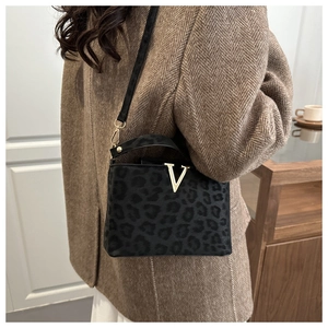 Détail du sac à main léopard avec logo V doré et texture en daim de haute qualité