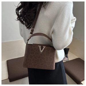 Détail du sac à main léopard avec boucle dorée en V et texture en daim de haute qualité
