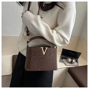 Détail d'un sac à main léopard marron avec logo V doré et une bandoulière ajustable